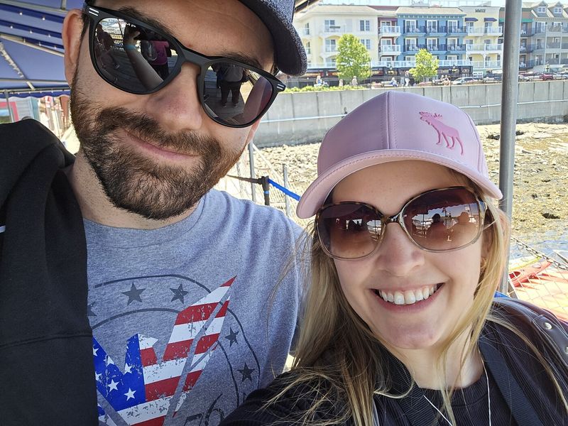 Steph and her husband smiling together on a sunny day trip