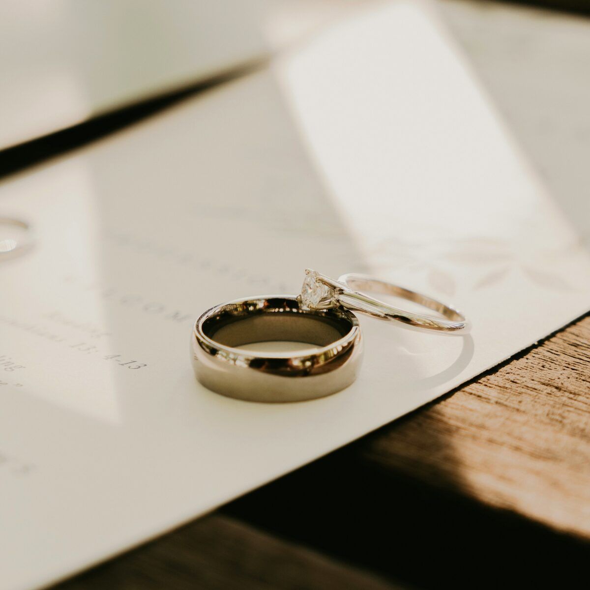 Wedding rings resting on an invitation suite